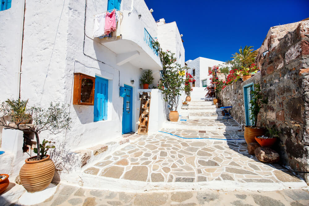 Strada nel vecchio villaggio tradizionale greco delle Cicladi di Plaka con case bianche e porte colorate sull'isola di Milos.